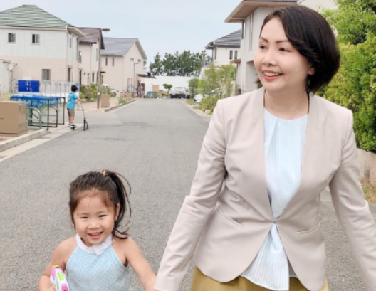 子供と手をつなぎ歩く孝岡知子氏